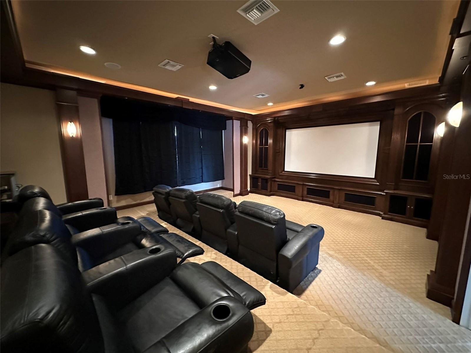 theatre room with reclining black chairs and projector